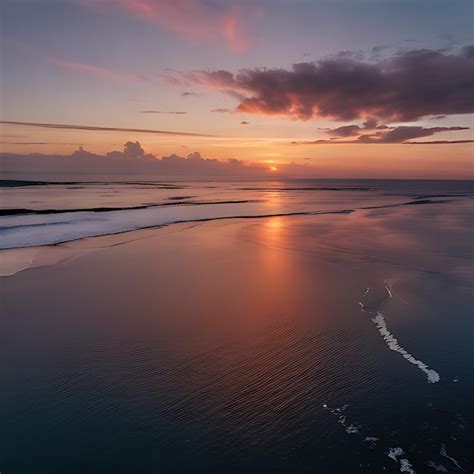 Premium Photo | A sunset over a beach with a wave in the water and a ...