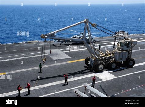 Us Sailors Direct A Crash And Salvage Crane On The Flight Deck Of The