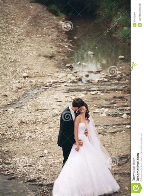 Beautifull Wedding Couple Kissing And Embracing Near The Shore Of A