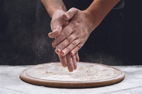 Premium Photo Bakers Hands In Flour On The Table Closeup Sprinkling