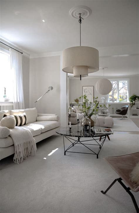 A Living Room Filled With Furniture And A Lamp Hanging Over The Top Of