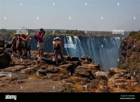 Tourists observing the magnificent beauty of the Victoria Falls, on the ...