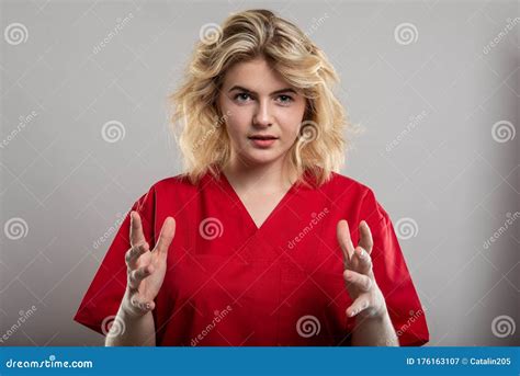 Portrait Of Female Nurse Wearing Red Scrub Holding Something Stock