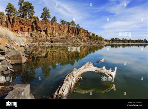 The calm waters of Fool Hollow Lake reflect the cliffs and sky. (Fool ...