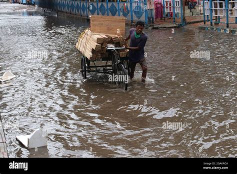 Commuters Wade Through A Waterlogged Street In Floodwaters Following