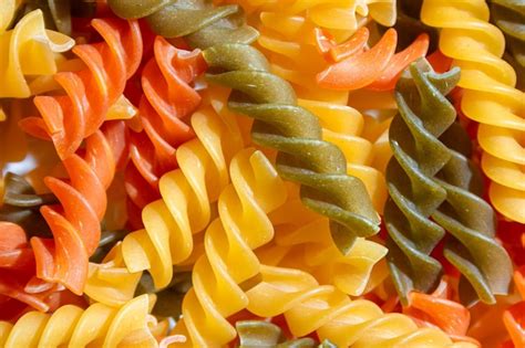 Premium Photo Uncooked Vibrant Colored Fusilli Pasta Background