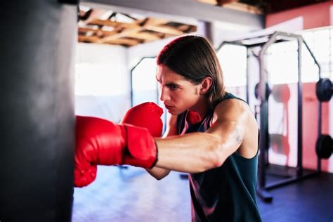 Premium Photo | Punching bag man and boxing in gym for exercise workout ...