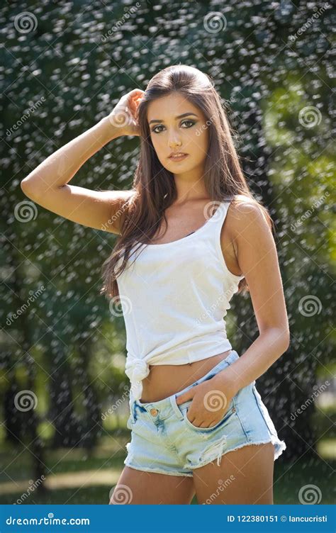 Retrato De La Mujer Atractiva En El Espray Del Agua Con La Camiseta