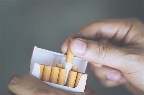 Close up mão de homem segurando descascá lo fora maço de cigarro