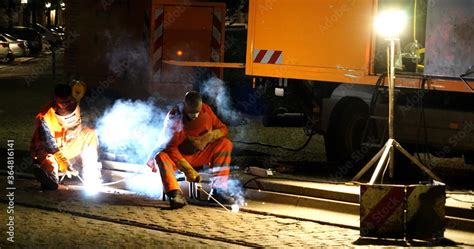 Foto De Nachtbaustelle Mit Einsatzfahrzeug Und Zwei Arbeitern Beim