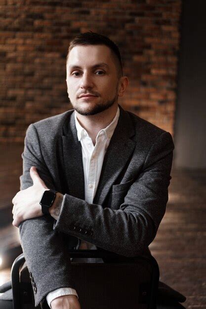 Retrato De Hombre Guapo De Moda Con Una Camisa Blanca Se Sienta En Una