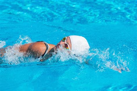 Female Swimmer In White Swim Cap And Goggles Performing Freestyle