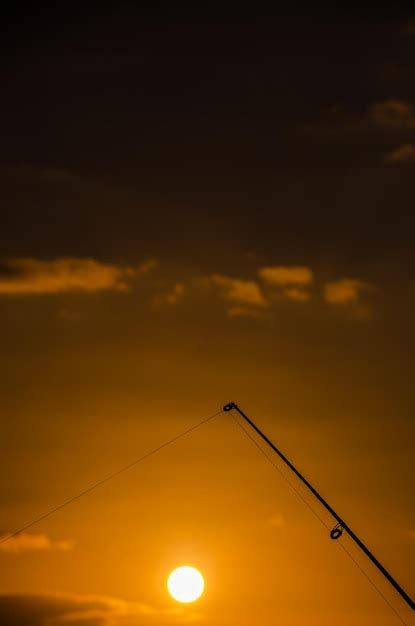 Silueta De Ca A De Pescar De Pescador Al Atardecer Naranja Foto Premium