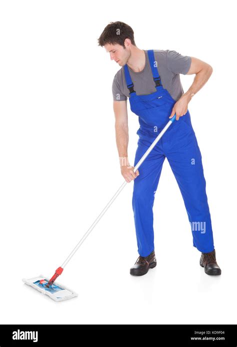 Young Man In Blue Uniform Cleaning The Floor Over White Background