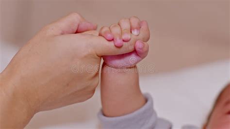 Close Up Hand Of Mother Holding Baby Newborn Foot With Love Small And