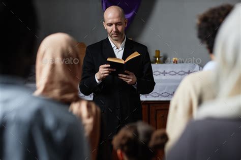 Preacher reading Bible for believers Stock Photo by seventyfourimages