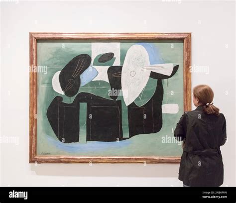 Une femme regarde un tableau Pablo Picasso intitulé instruments de