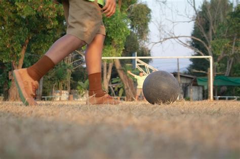 Un muchacho que golpea el balón de fútbol con el pie en campo de