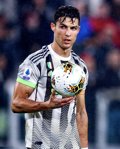 A Man Holding A Soccer Ball On Top Of A Field