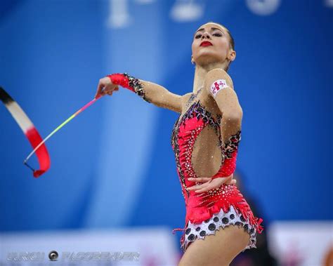 A Woman In A Red And White Dress Holding A Badminton Racquet