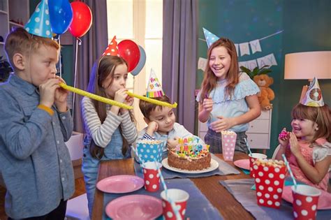 Niños felices con gorros de fiesta celebrando un cumpleaños Foto Premium