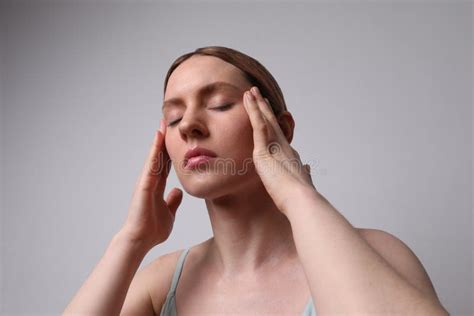 Middle Aged Woman Touches Her Face Doing A Lift Massage Posing On White