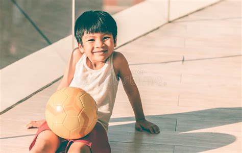 Young Boy Sitting with Soccer and Smiling Stock Photo - Image of ethnicity, yellow: 142227182