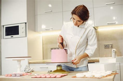 Concentrated Female Pastry Cook Decorating Cake With Pleasure In Modern Restaurant · Free Stock