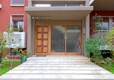 modern apartment building entrance  potted plants   glass