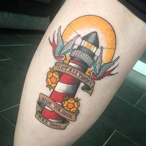 A Tattoo With A Lighthouse And Ribbon Around It