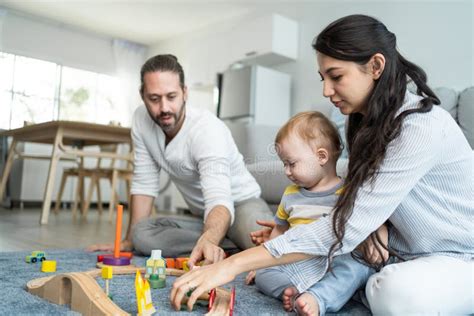 Caucasian Happy Loving Parent Play With Baby Toddler In Living Room