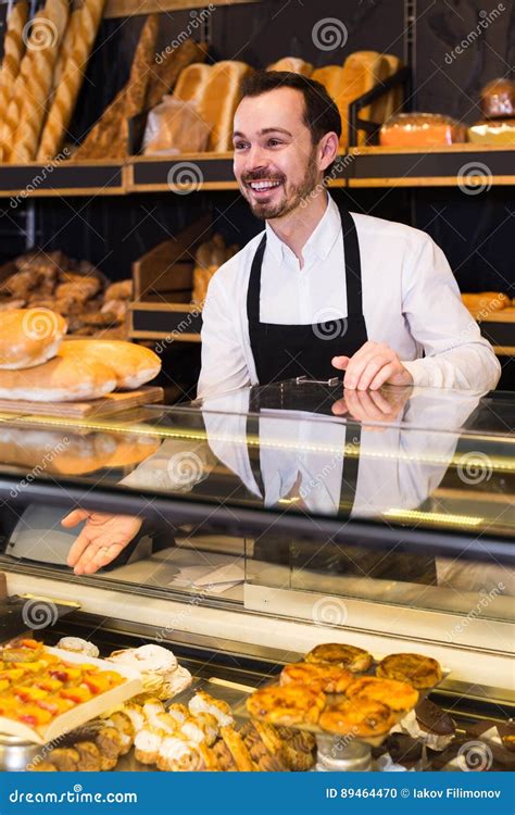 Male Shop Assistant Demonstrating Fresh Delicious Pastry In Bake Stock