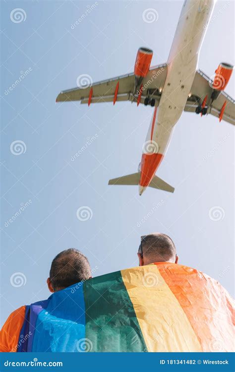 Vertical Shot Of A Gay Couple Standing Under An Airplane Stock Photo Image Of Hands Partner