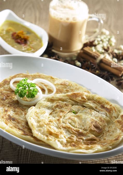 Roti Canai Served With Curry With Teh Tarik As Background Stock Photo