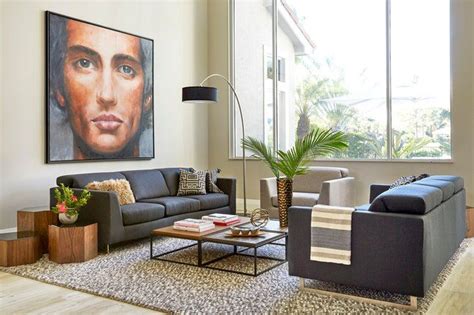 A Modern Living Room With A Large Portrait Of A Mans Face On The Wall