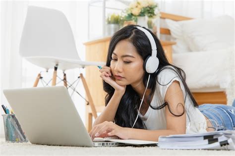 Premium Photo Woman Wearing Headphones Using Laptop On Carpet