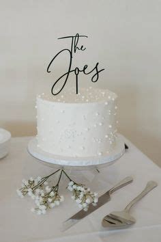 A White Wedding Cake With The Word The Jones On It And Some Silverware