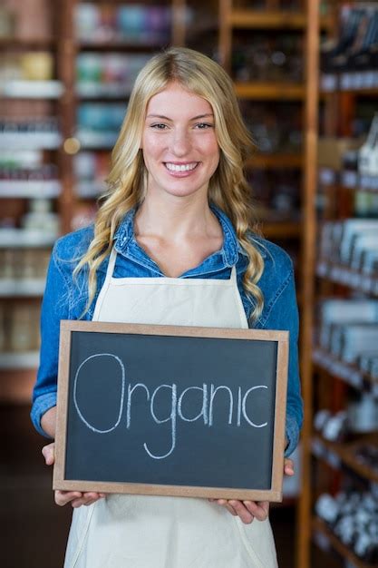 Premium Photo Portrait Of Smiling Female Staff Holding A Organic Sign