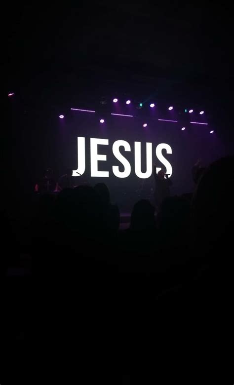 The Word Jesus Is Projected On A Dark Stage