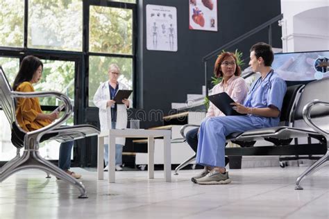 Medical Nurse Taking Notes At Examination With Senior Asian Patient