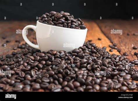 Close Up Shot Of Dark Roasted Coffee Bean In White Ceramic Cup On