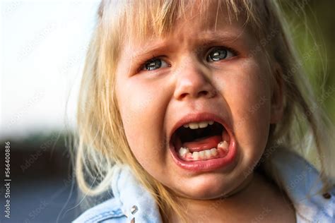 Unhappy child crying loudly with mouth open because of his parents ...