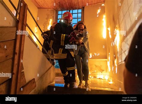 Brave Fireman Descends Stairs Of A Burning Building And Holds Saved