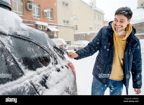 Happy Man Removing Snow With Brush From Car Stock Photo Alamy