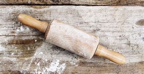 A Wooden Rolling Pin Sitting On Top Of A Wooden Table