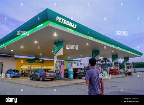 man walks  petronas gas station daily life photo  petronas gas