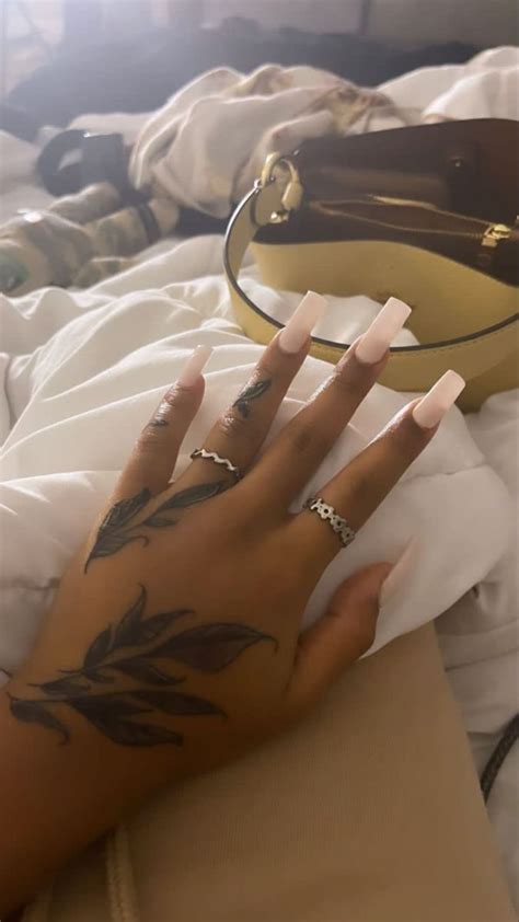 A Woman S Hand With Tattoos On Her Left Arm And The Other Hand Holding