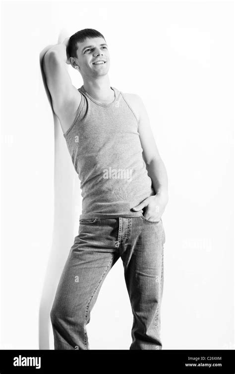 Portrait Of Young Handsome Brunet Guy In Undershirt And Jeans Posing On