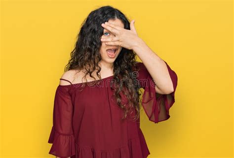 Young Hispanic Girl Wearing Casual Clothes Peeking In Shock Covering