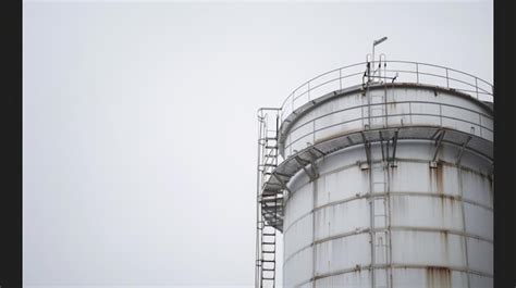 Large Industrial Water Tank Standing Under Cloudy Sky Premium AI